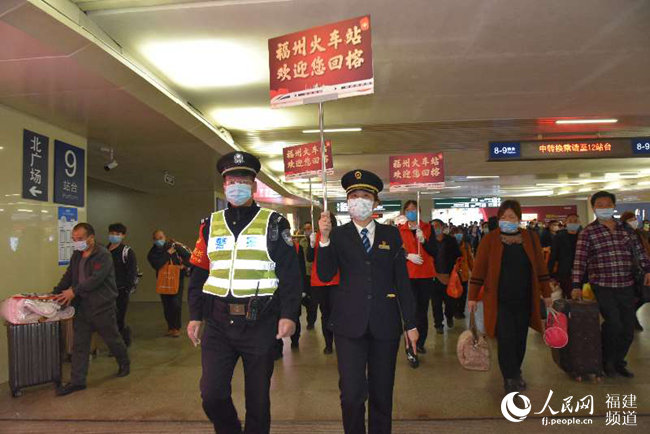 福州火車站黨團員青年突擊隊和值班鐵路民警引導旅客出站。 江曲攝
