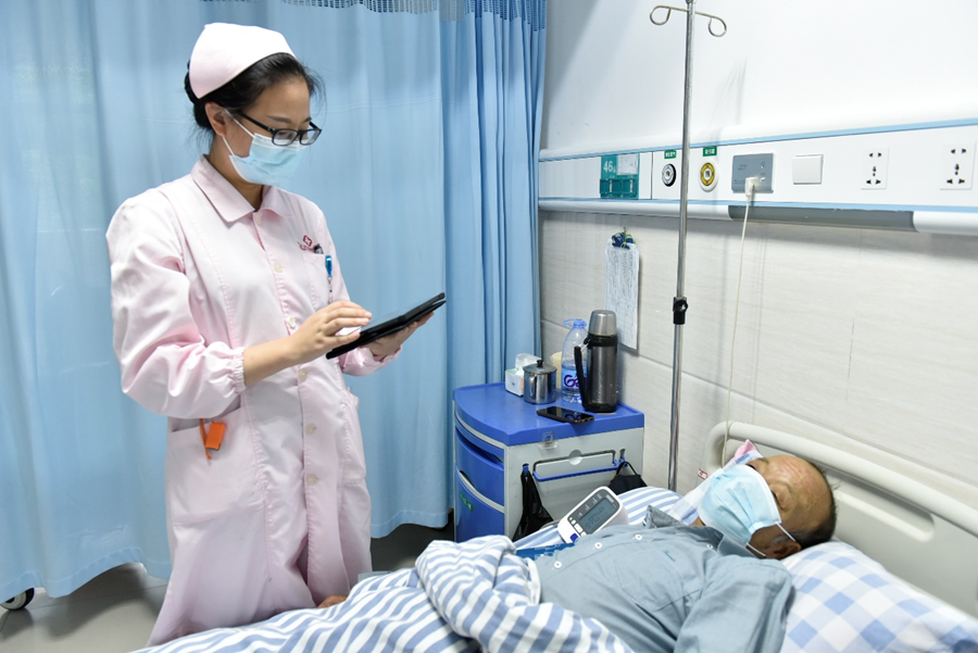 疾病管理師施燕萍為病人測量血壓，並將結果計入院中疾病管理系統。羅姮攝